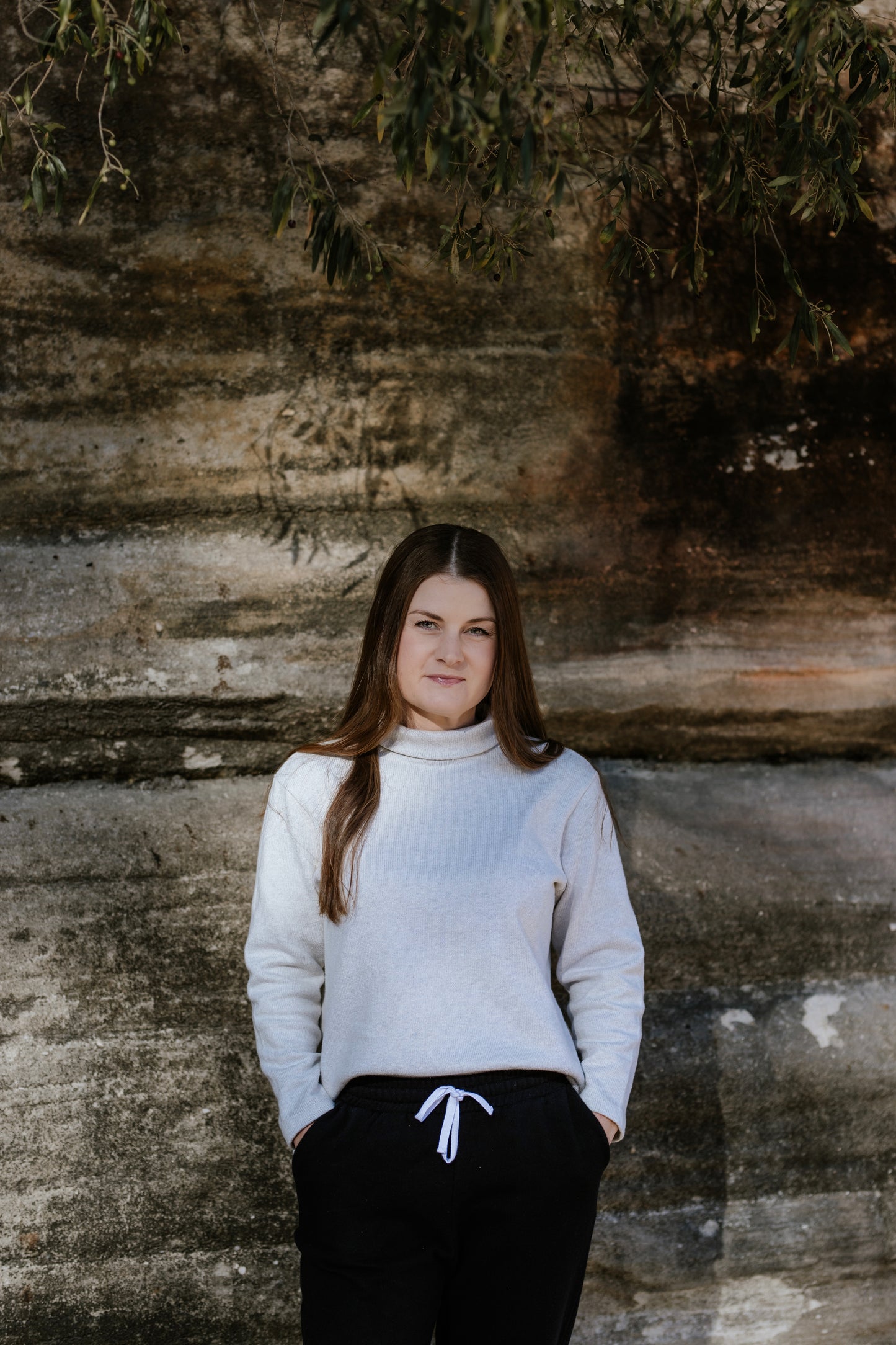 Short, petite woman wearing a turtleneck knit jumper/sweater.